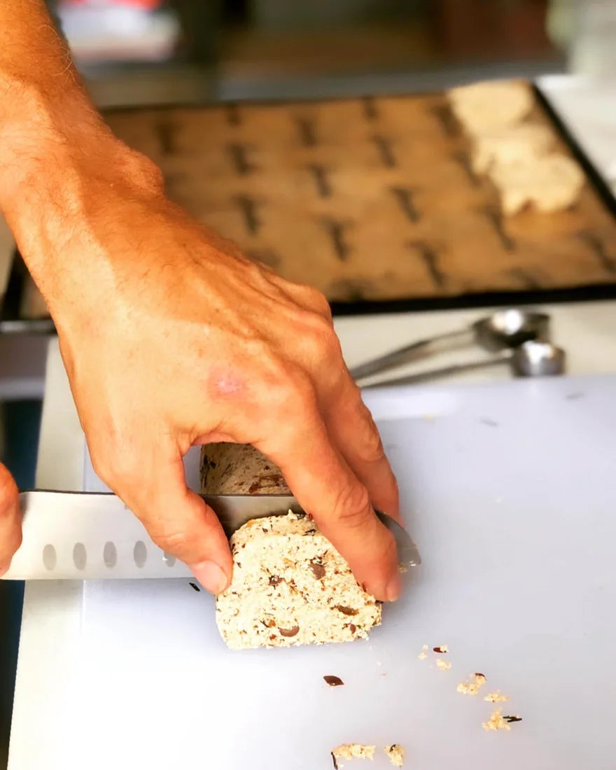 A student slicing a handmade raw loaf