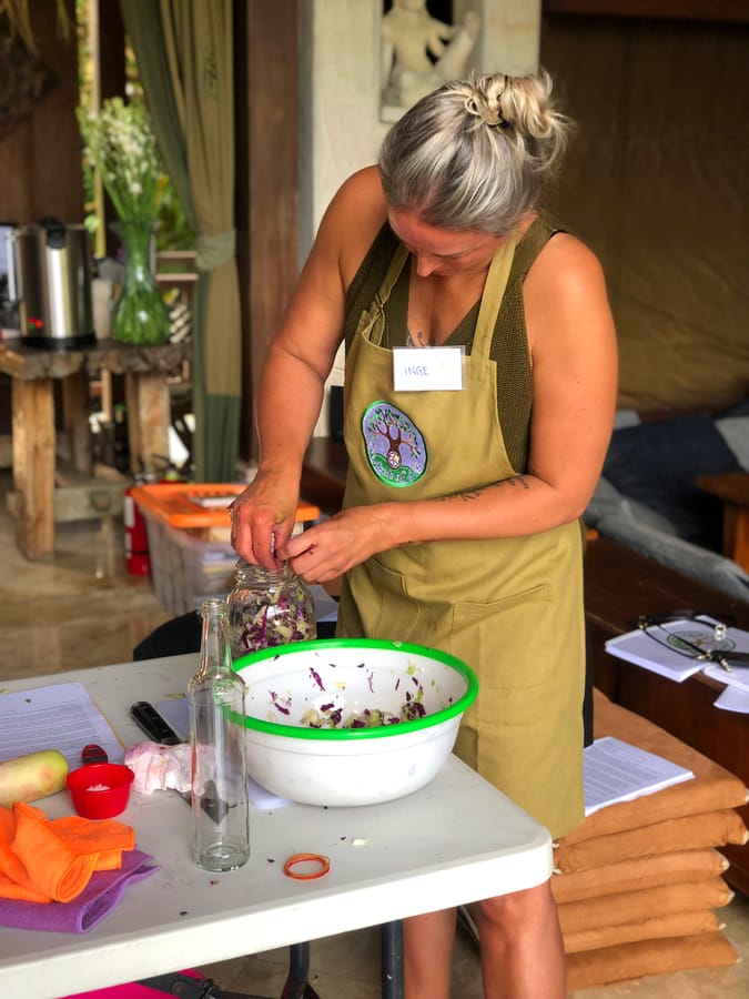 A student packing a fermentation jar in her Seeds of Life apron