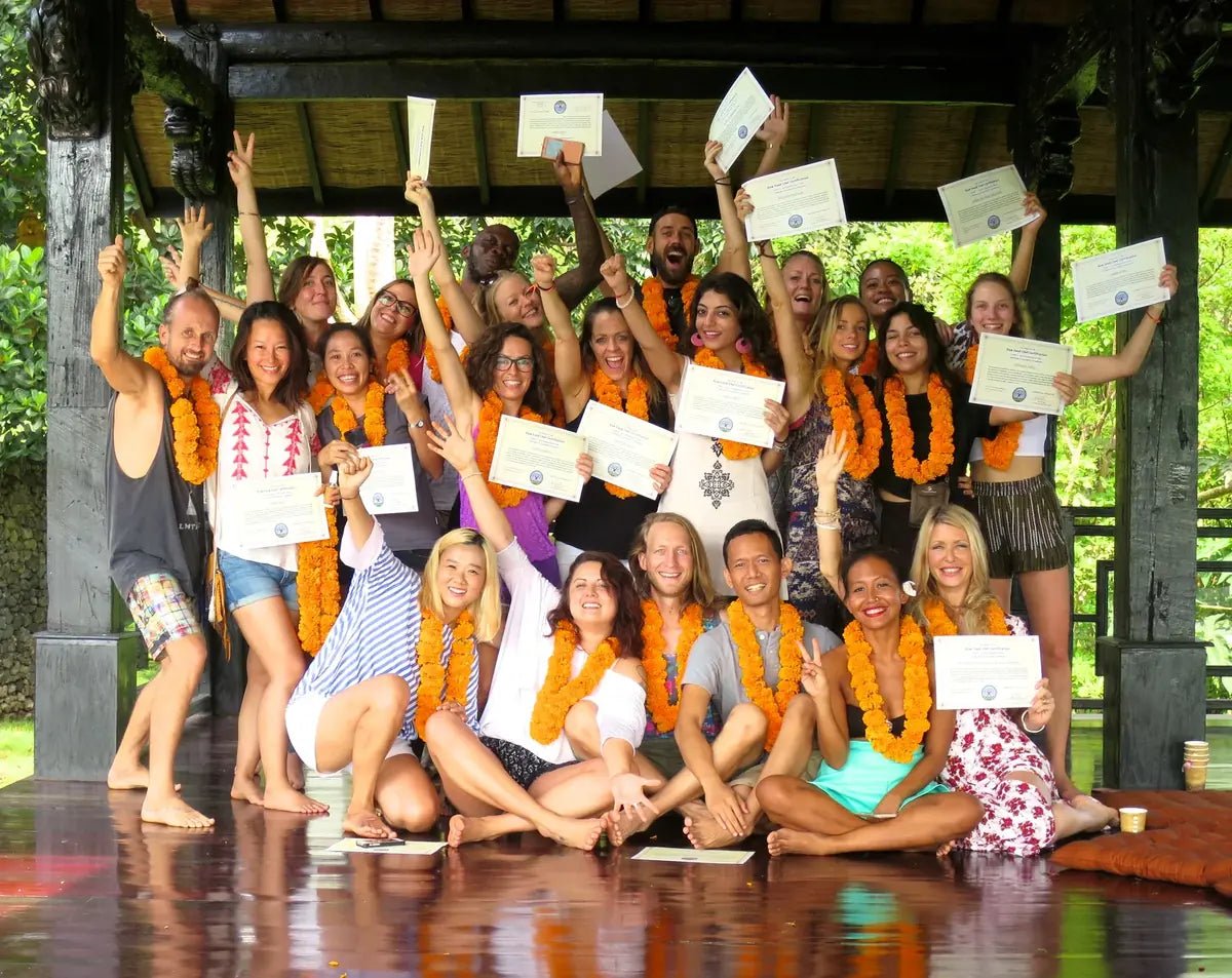 Raw chef graduates wearing orange garlands and celebrating with certificates in Bali